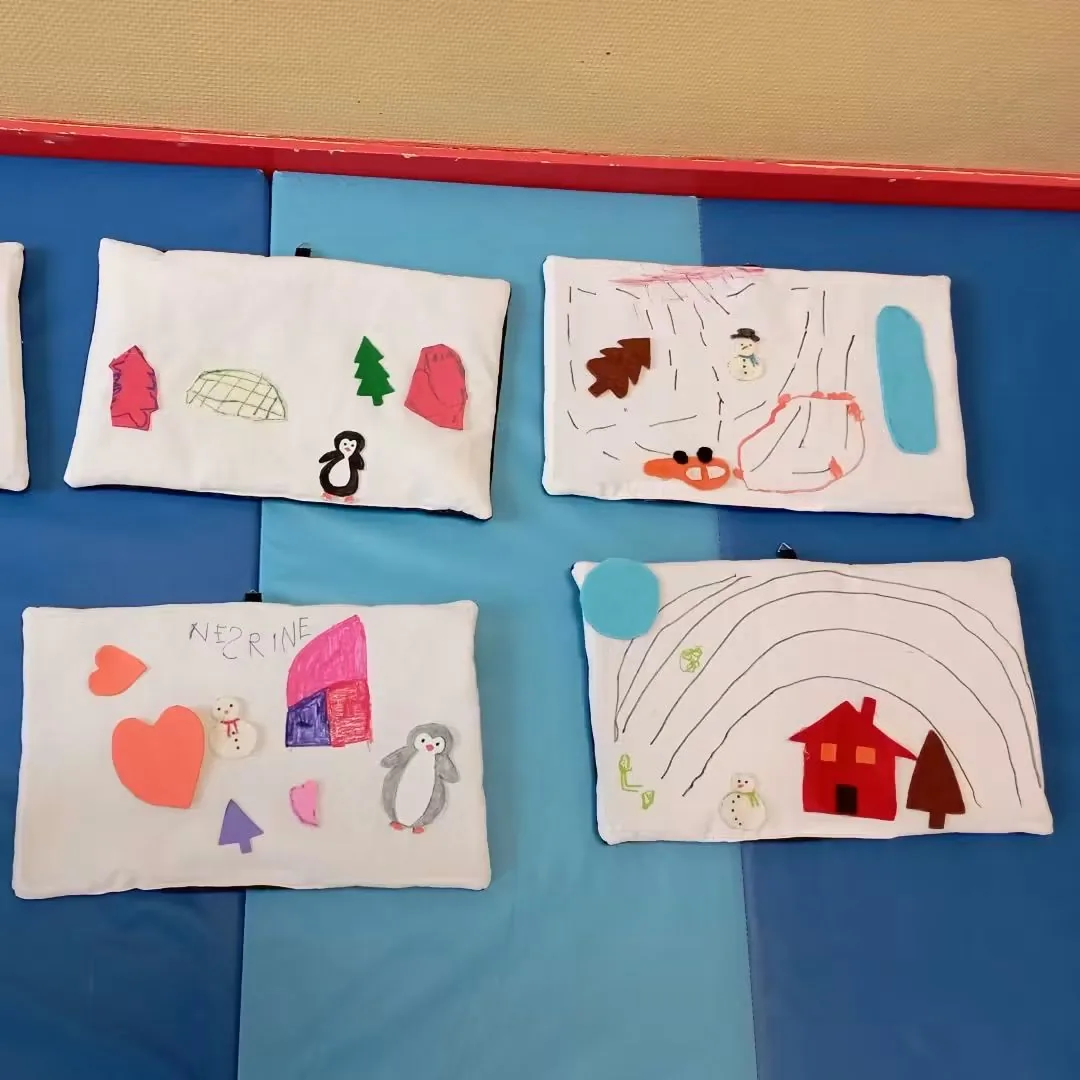 Quatre mini-tapis de lecture réalisés par des enfants : maison, mer, pingouin, feux d'artifice